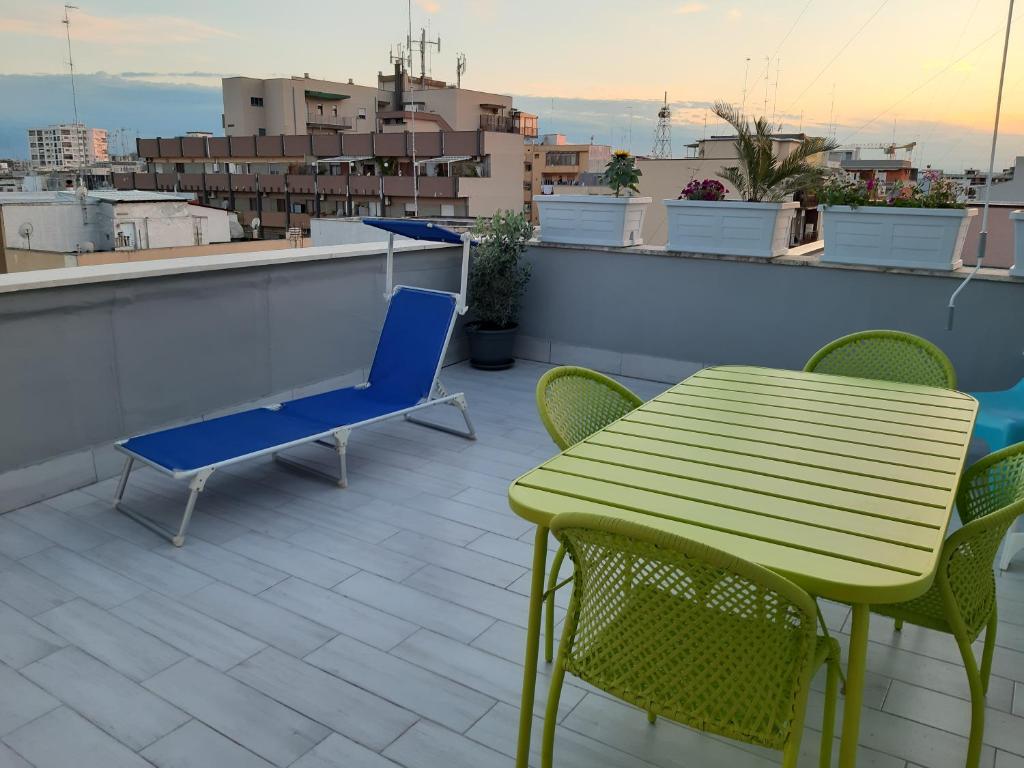 une table et des chaises vertes sur le toit dans l'établissement Attico Con Terrazza A Bari, à Bari