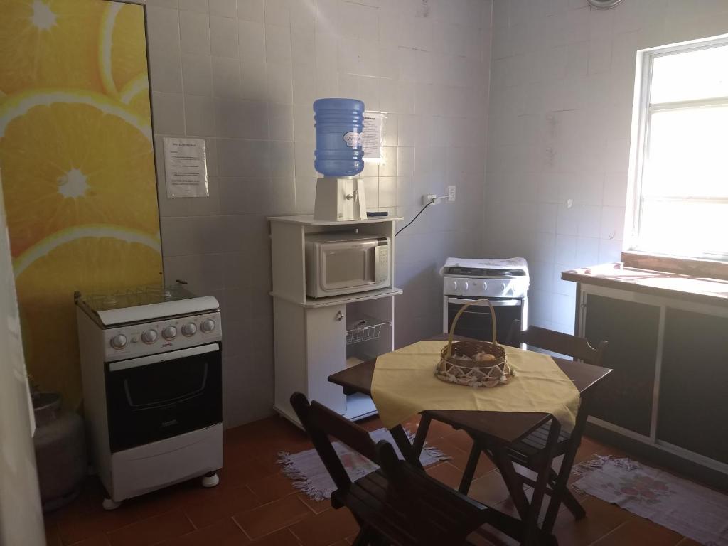 a kitchen with a table with chairs and a microwave at Hostel Beira Mar in Ilha Comprida