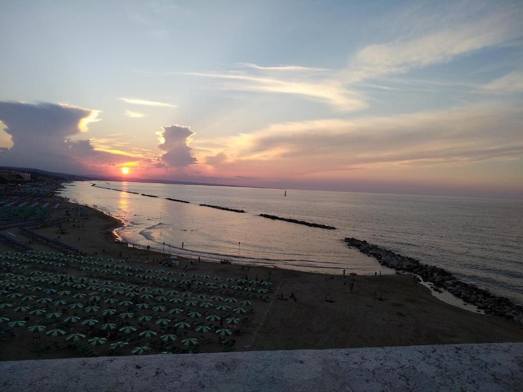 un tramonto su una spiaggia con ombrelloni e l'oceano di La Casetta nel Borgo a Termoli