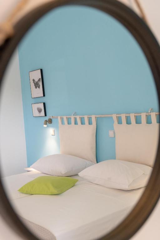 a mirror reflection of a bed with white pillows at Kassiani Studios in Plakias