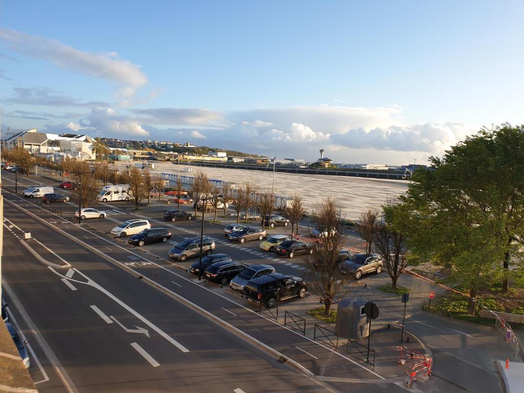 ein Parkplatz mit Autos neben einem Fluss in der Unterkunft Appartement La Vue Sur Mer in Boulogne-sur-Mer