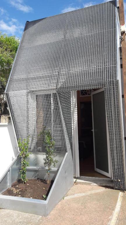un bâtiment avec une cage comportant deux plantes dans l'établissement Maison 2 chambres, cosy, proche Métro, à Toulouse