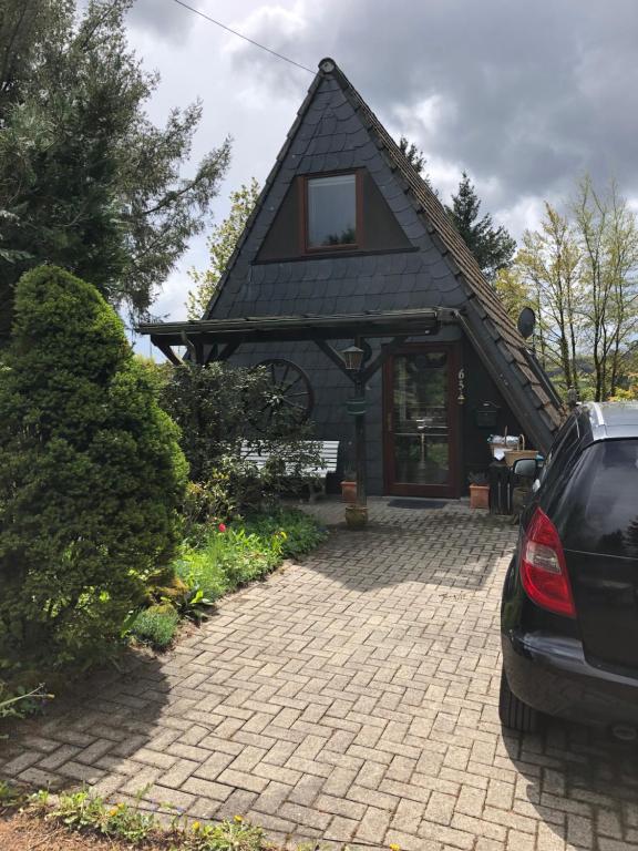 uma casa com um carro estacionado em frente em Eifelwolke em Kerschenbach