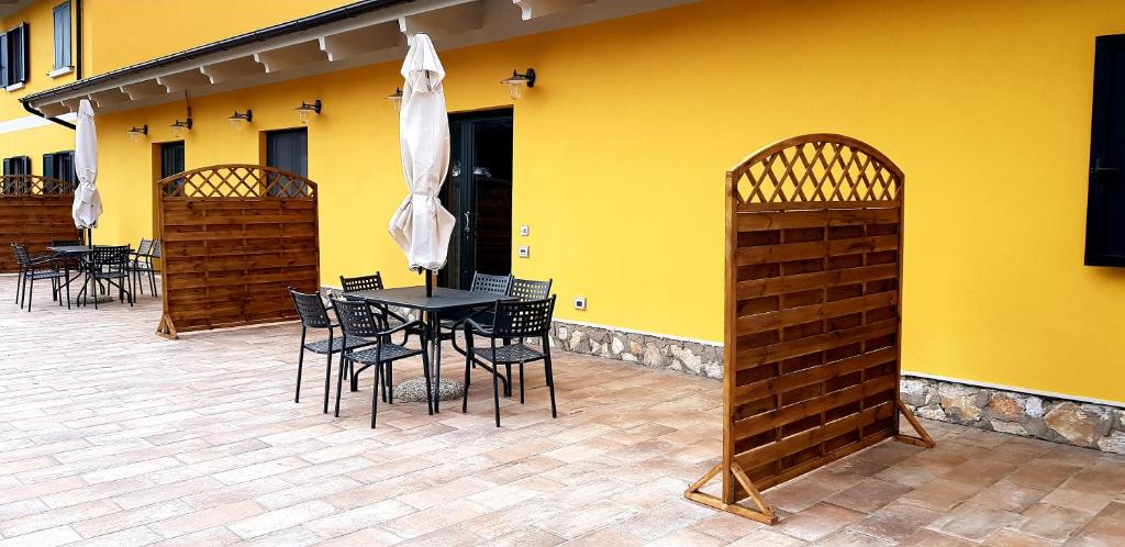 a patio with a table and chairs and a yellow wall at La Fattoria di Tirrenia in Tirrenia