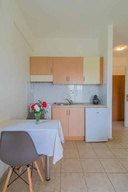 a kitchen with a table with a vase of flowers on it at Kassiani Studios in Plakias