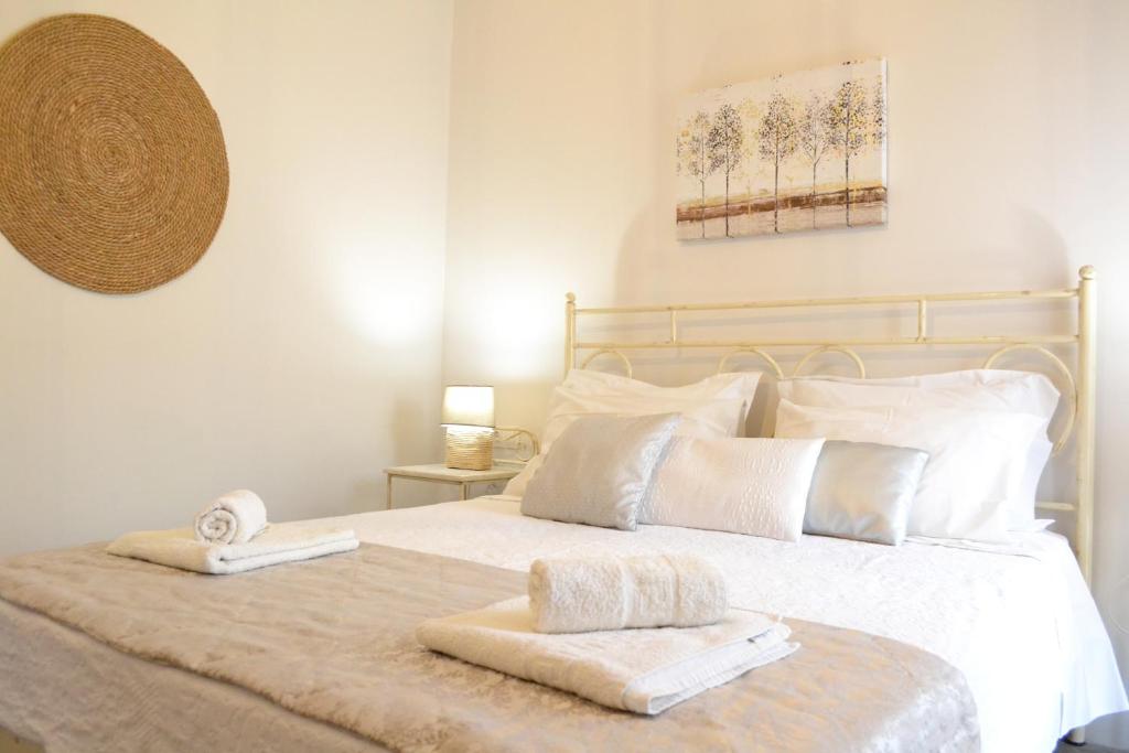 ナクソス・コラにあるAriadne & Theseus Apartmentsのベッドルーム1室(白いベッド1台、タオル2枚付)