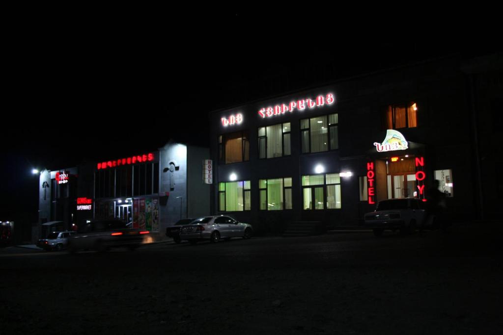 un edificio con un coche aparcado delante de él por la noche en Hotel Noy en Goris