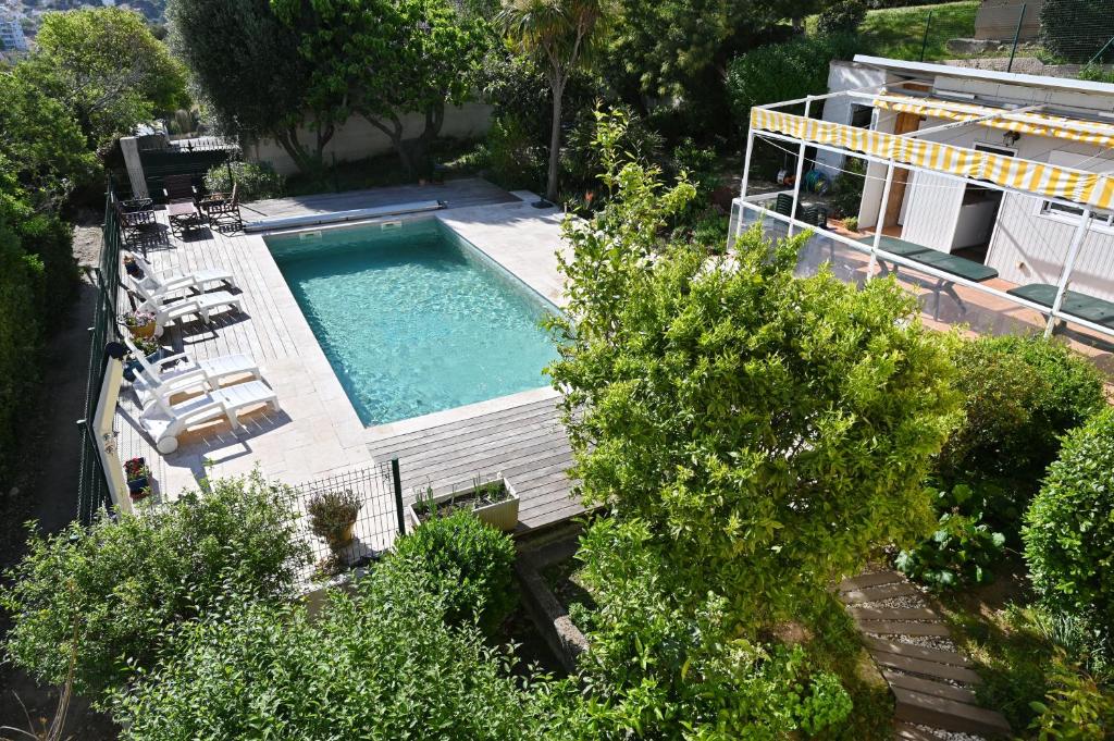 - une vue sur la piscine bordée de chaises et d'arbres dans l'établissement Villa Eveil, à La Seyne-sur-Mer