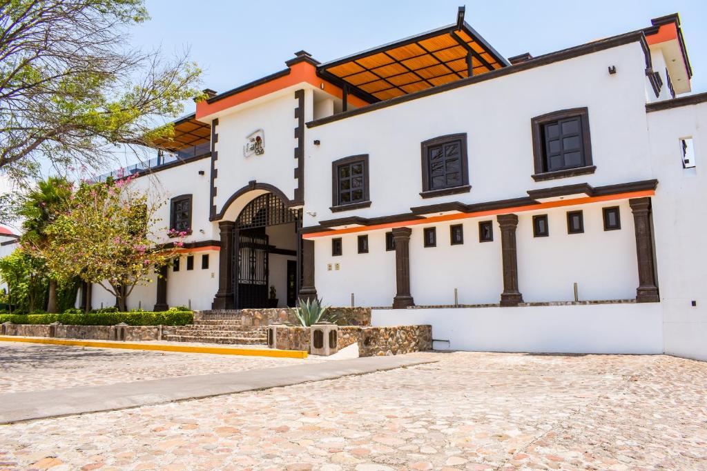 un grand bâtiment blanc avec un toit orange dans l'établissement The Latit Hotel Querétaro, à Querétaro