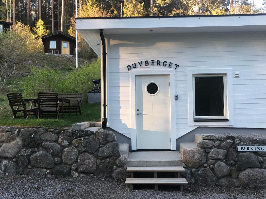 a white building with a door and a sign on it at Duvberget in Kolmården