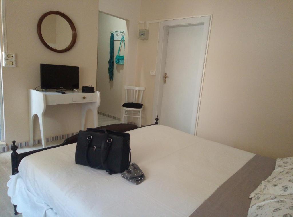 una bolsa negra sentada en una cama en un dormitorio en La villa, en Bellaria-Igea Marina
