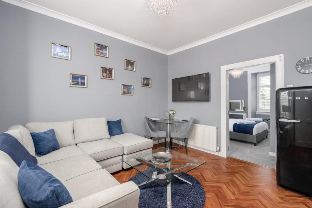 a living room with a white couch and a tv at No 10 - by StayDunfermline in Dunfermline