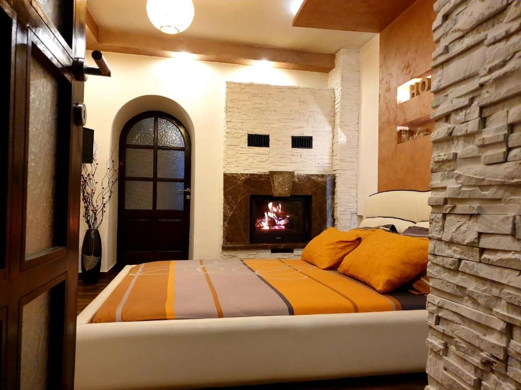 um quarto com uma cama e uma lareira em Apartmani vuk em Cetinje