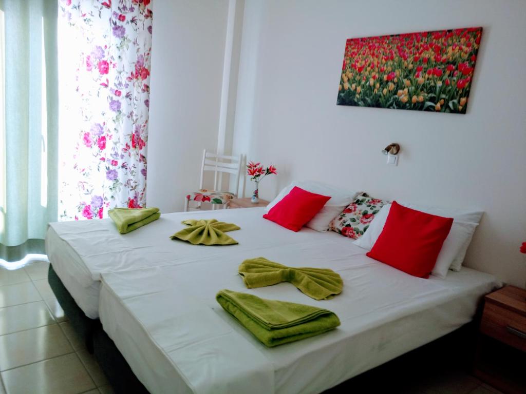 a bedroom with a bed with red and green towels on it at Meletis Studios in Parikia