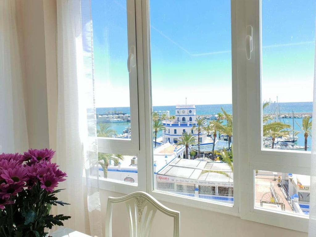 Habitación con ventana y vistas al océano. en FANTASTIC APARTMENT B IN FRONT OF THE SEA & MARINA, en Estepona