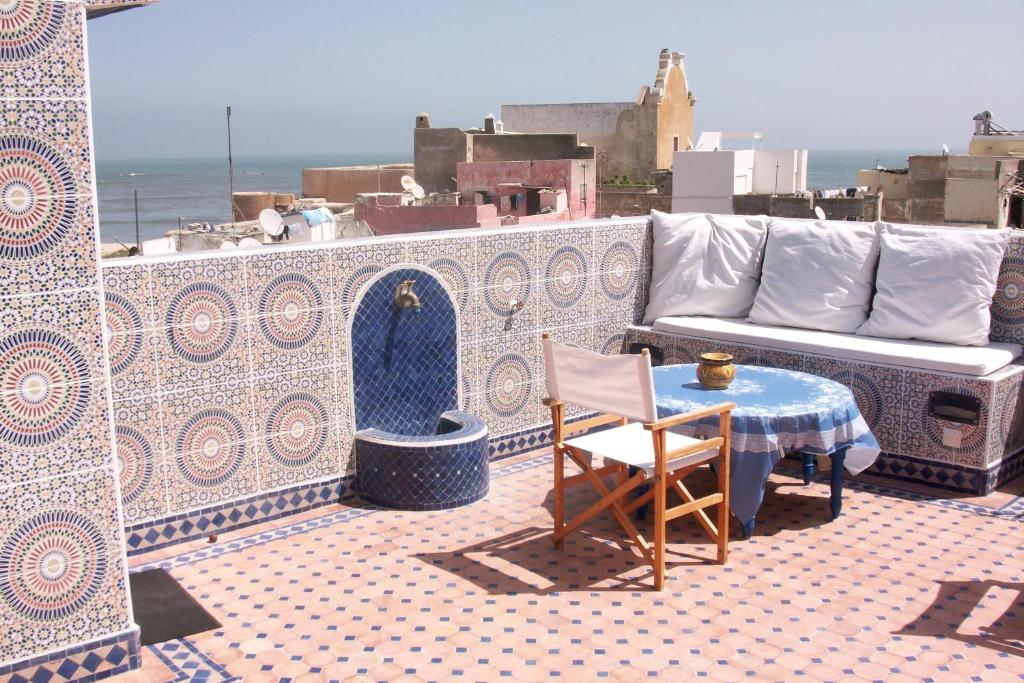 un patio con sofá, mesa y sillas en Dar El Jadida, en El Jadida