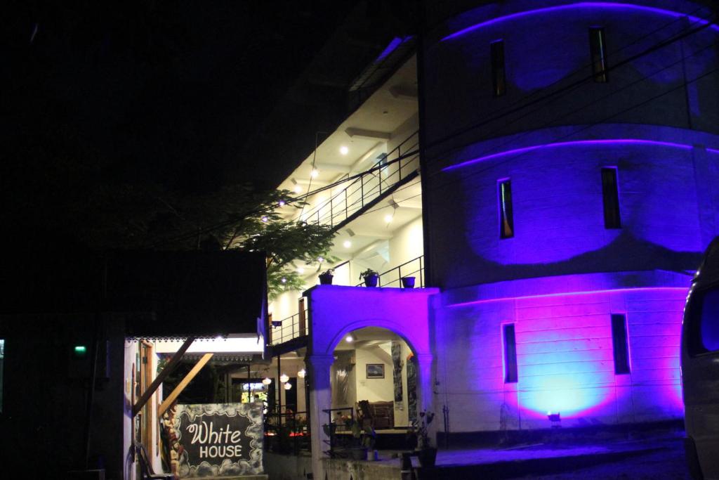 a building with purple lights on it at night at White House Adam`s Peak in Nallathanniya
