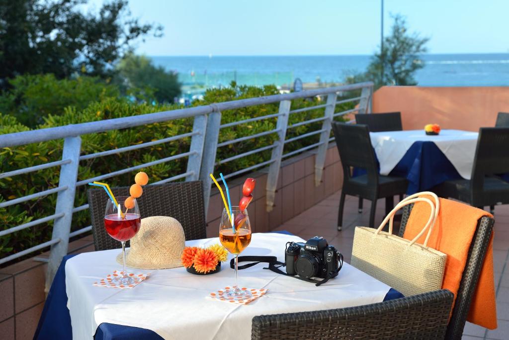 un tavolo con due bicchieri di vino sul balcone di Hotel Rossini a Pesaro
