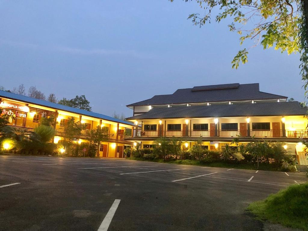un bâtiment avec un parking en face de celui-ci dans l'établissement Hugpua Hotel, à Nan