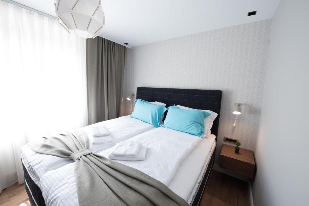 a bedroom with a large bed with blue pillows at Boulevard Exclusive in Prishtinë