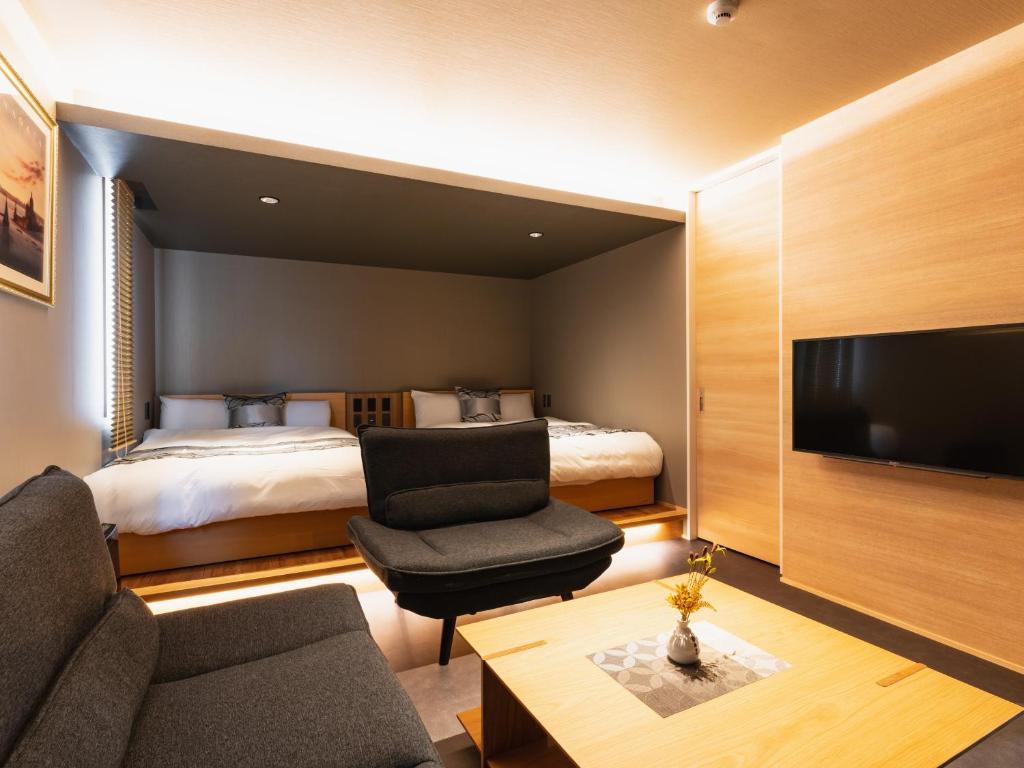 Habitación de hotel con cama y TV en GRAND BASE Beppu Ekimae, en Beppu