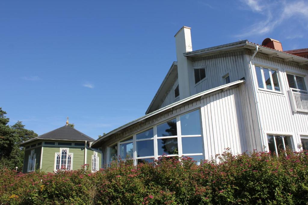 een groot wit huis met een groen bij Åh Stifts- & Konferensgård in Ljungskile