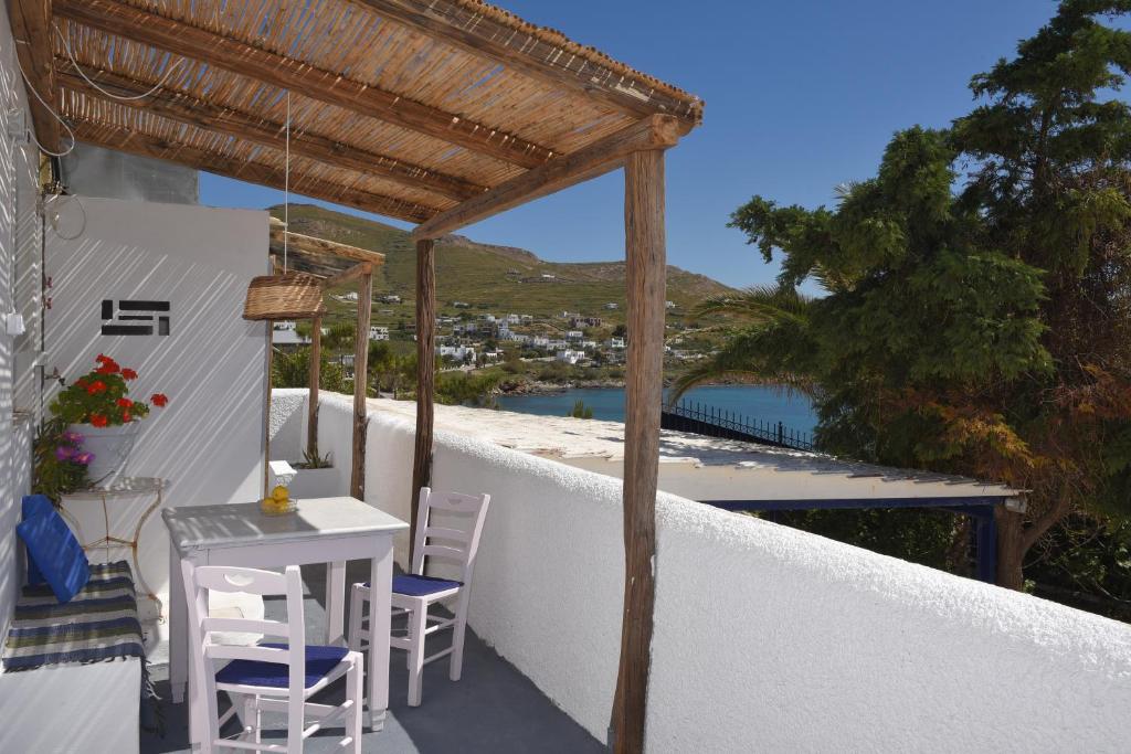 patio con mesa y sillas en el balcón en VILLA PETROS SEA SUITE, en Megas Gialos - Nites