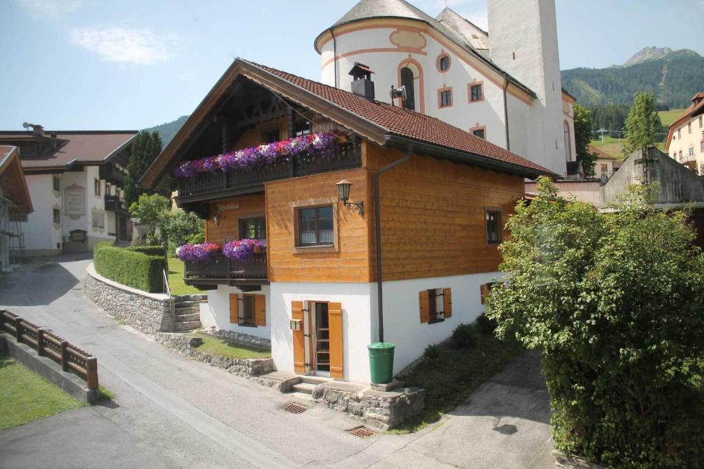 a building with flowers on the top of it at Ferienhaus Jägerhäusl in Lermoos