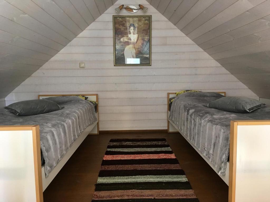 2 Betten in einem Dachzimmer mit einem Bild an der Wand in der Unterkunft Heinaka Kodu in Rakvere