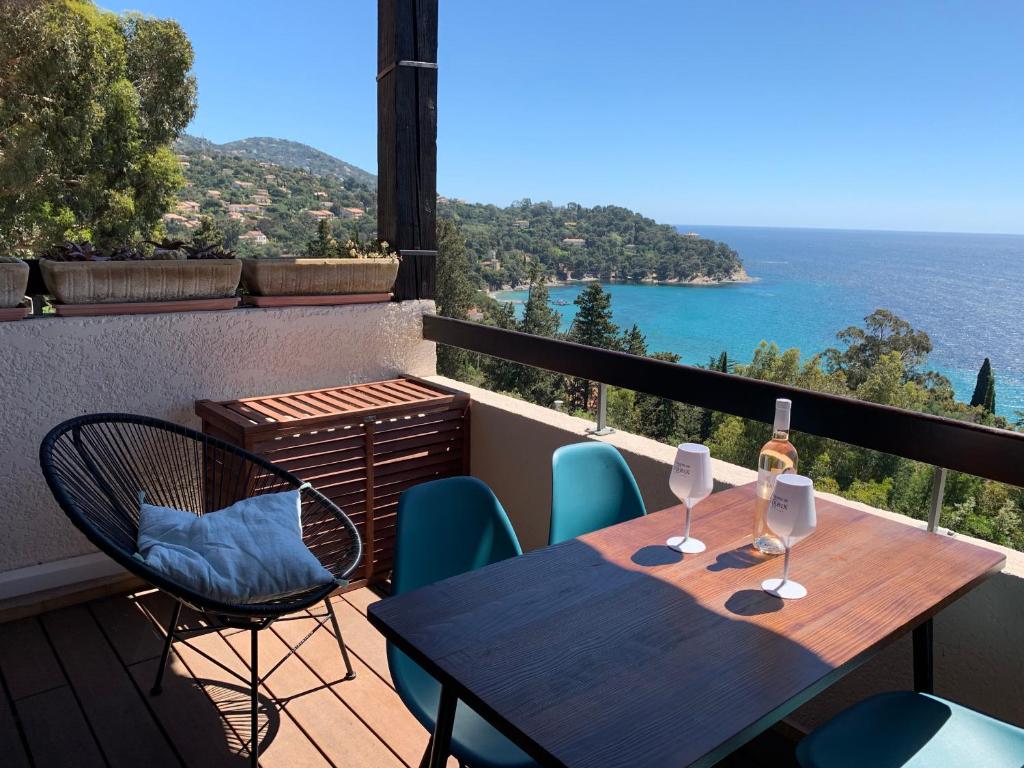 einen Tisch und Stühle auf einem Balkon mit Meerblick in der Unterkunft Appartement - Résidence Le Paradou in Rayol-Canadel-sur-Mer