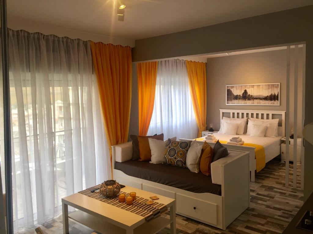 een slaapkamer met een bed, een bank en een tafel bij Alektor in Kavala