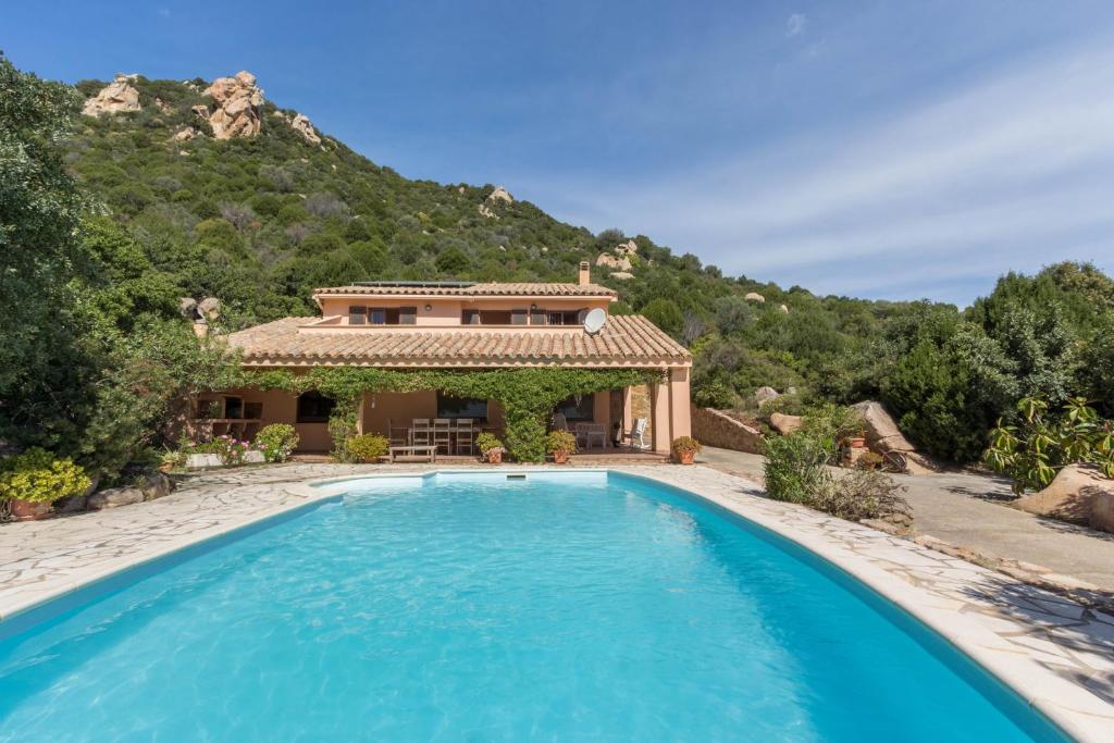 a villa with a swimming pool in front of a house at Villa Bellavista con piscina privata, vista mare vicino a Villasimius in Villasimius