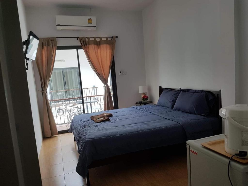 a bedroom with a blue bed and a balcony at Amaretto & Caffe Hostel in Surat Thani