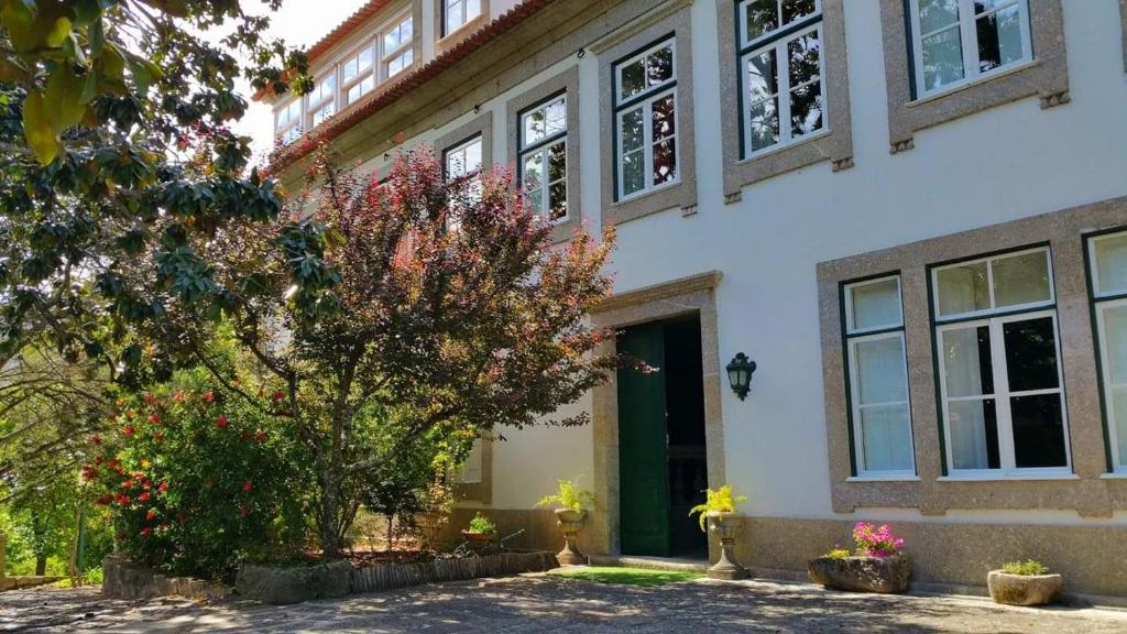 uma casa com uma árvore em frente em Quinta da Ermida - Turismo de Habitacao em Baião