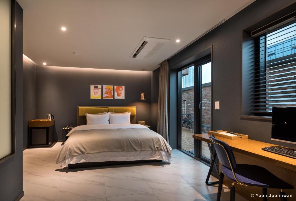 釜山にあるBrown Dot Hotel Seomyeonのベッドルーム1室(ベッド1台、デスク、コンピュータ付)