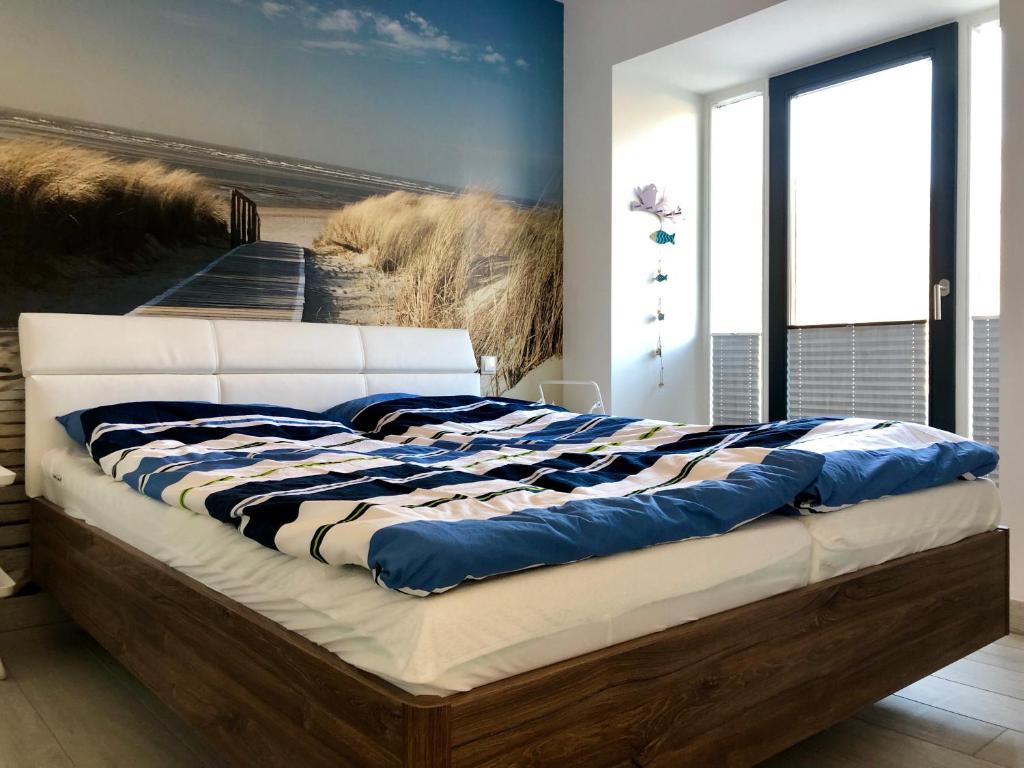 Schlafzimmer mit einem Bett mit Wandgemälde in der Unterkunft Strandapartment Meeresrauschen Prora Binz EG in Binz