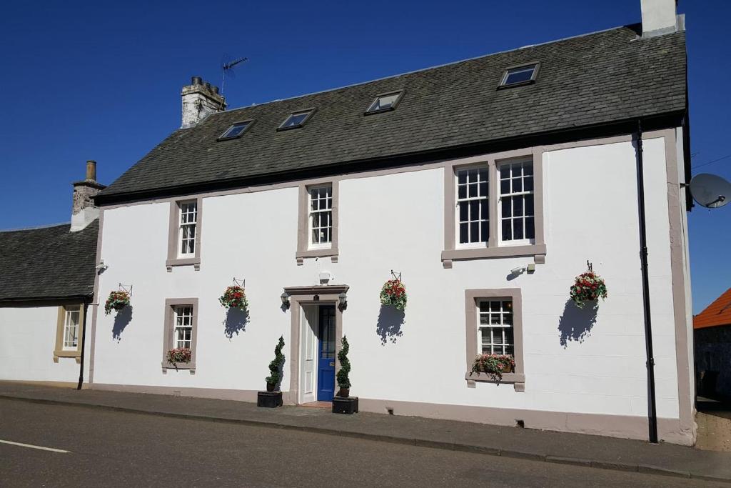 un edificio blanco con flores en las ventanas en Thornhill House - Historic 5 Bedroom 5 Ensuite en Stirling