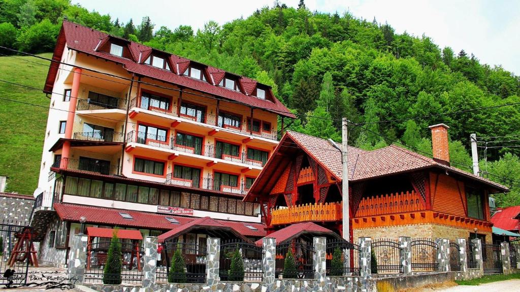 a large building in front of a mountain at Pensiune Restaurant Piatra Craiului in Dîmbovicioara