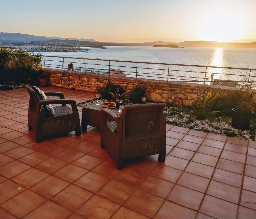 un patio con 2 sillas y una mesa con vistas al océano en Sody Magnificent Bay View, en La Canea
