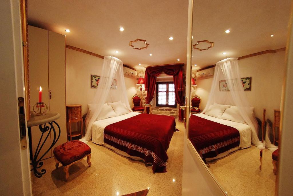 - une grande chambre avec 2 lits et un miroir dans l'établissement VG Three Bedroom Castle, à Kotor