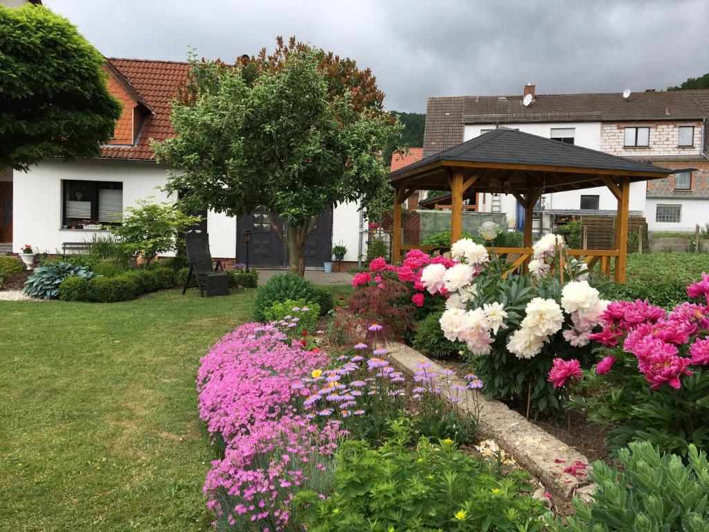 ハイルバート・ハイリゲンシュタットにあるIm Herzen Deutschlands entspannenのガゼボと色鮮やかな花々が咲く庭園