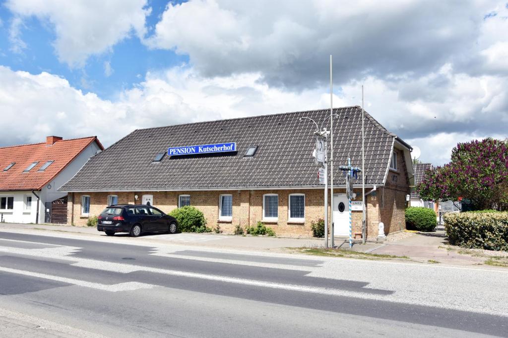 ein Gebäude mit einem blauen Schild darüber in der Unterkunft Kutscherhof Broock in Broock