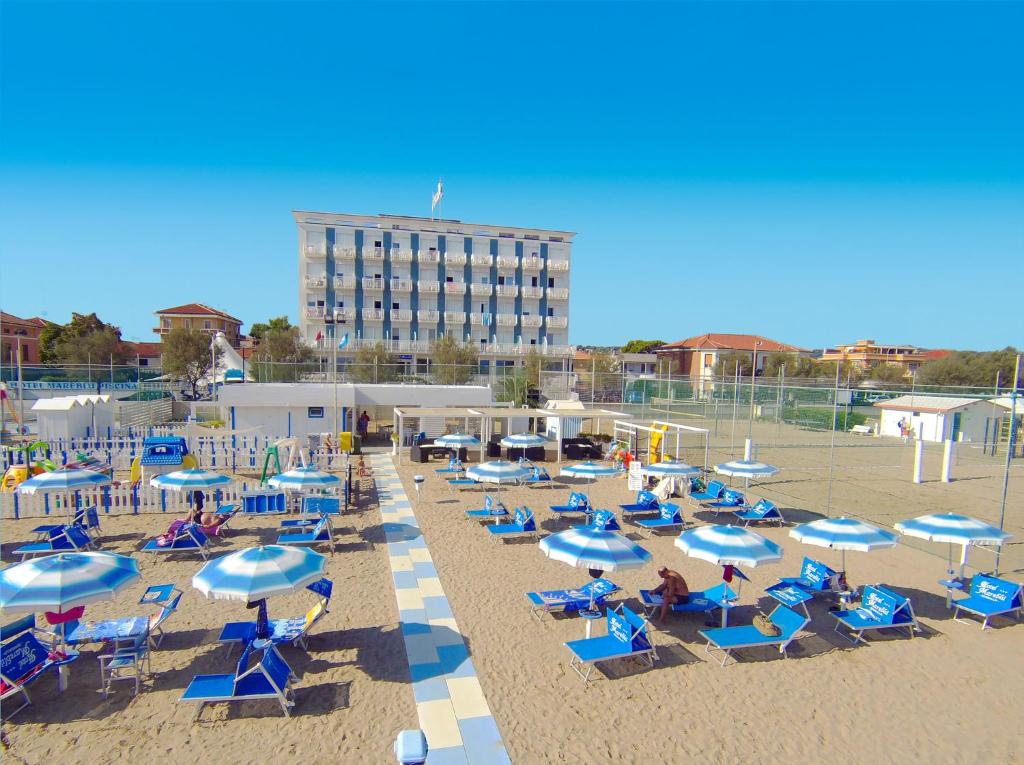 a beach with chairs and umbrellas and a hotel at Hotel Mareblu in Senigallia