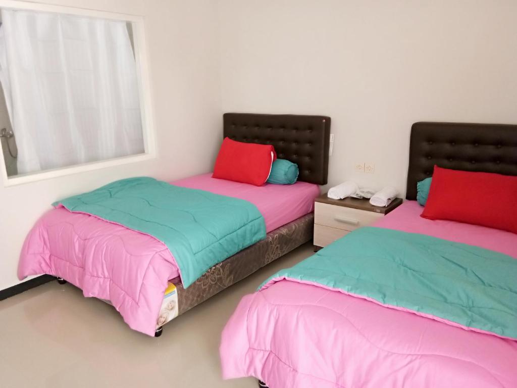 twee bedden naast elkaar in een slaapkamer bij Villaloe in Bromo