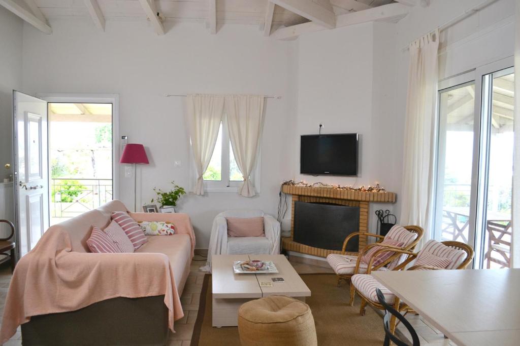 salon z kanapą i telewizorem w obiekcie Corinthian Sun - Vacation Home w mieście Korynt
