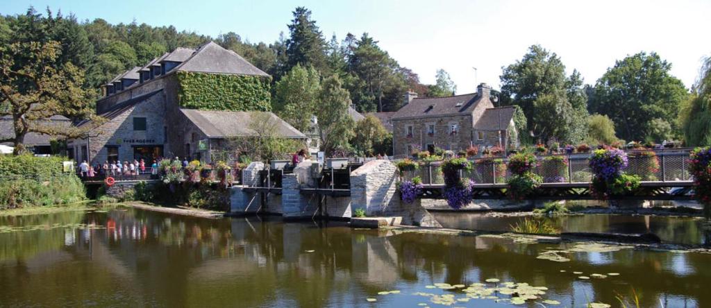 a large building with a pond in front of a house at Rives Nature in La Gacilly