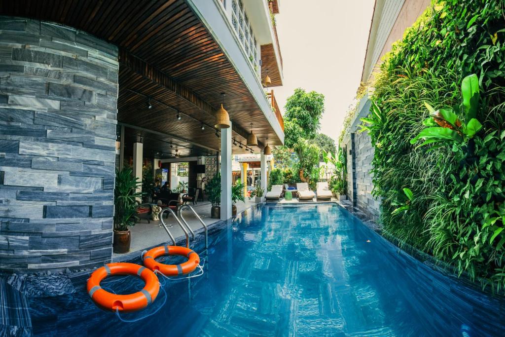 una piscina infinita con dos balsas salvavidas anaranjadas en una casa en La An Central Boutique Villa en Hoi An