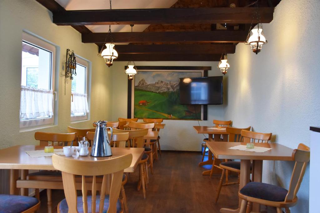 a restaurant with wooden tables and chairs and a tv at Kutscherhof Broock in Broock