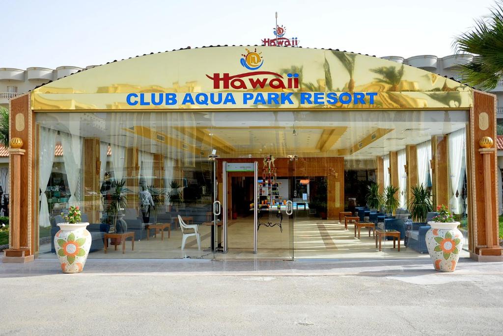 Hawaii Riviera Club Aqua Park - Families and Couples Only في الغردقة: مبنى به لافته لمنتجع كوالا كلوب بارك