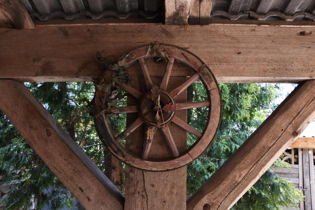 an old woodenoked wheel on a wooden structure at Kutscherhof Broock in Broock